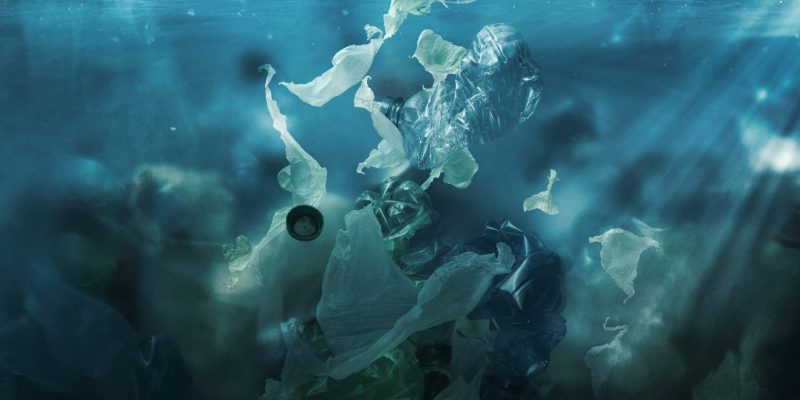 Toxic plastic waste floating underwater in the ocean, water pollution and environmental damage concept